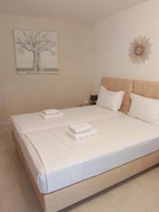 a bedroom with a bed with two towels on it at Colors Apartments Pilio in Afissos