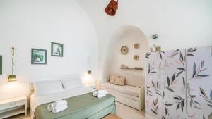 a living room with a bed and a couch at Casetta Carlotta by Rentbeat in Ostuni