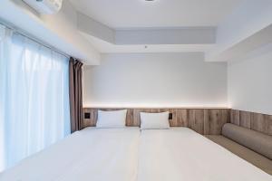 Łóżko lub łóżka w pokoju w obiekcie Apartment Hotel 11 Nagoya