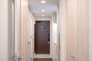 korytarz z brązowymi drzwiami w pokoju w obiekcie Apartment Hotel 11 Nagoya w mieście Nagoja