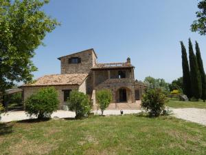 an old stone house with trees in front of it at Scappo in Umbria, Casale Lenuccia in Collelungo