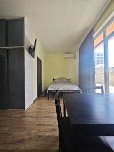 Un dormitorio con una cama y una mesa en una habitación. en Sunny Studio Near the Sea, en Kobuleti