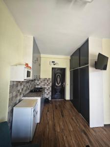 Una cocina con gabinetes blancos y un refrigerador negro. en Sunny Studio Near the Sea, en Kobuleti