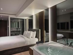 a hotel room with a bed and a bath tub at Nur Edge Aparthotel - Acropolis Skyline in Athens