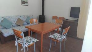 a dining room with a table and chairs and a couch at Ca' tommy in Ceppo Morelli