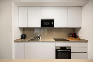 a kitchen with white cabinets and a microwave at Luxury 3bed-Apartment with Stunning Sea Views in Rincón de la Victoria +25 photos