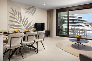 a living room with a dining room table and chairs at Luxury 3bed-Apartment with Stunning Sea Views in Rincón de la Victoria