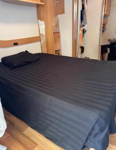 un letto in una stanza con un lenzuolo nero di Coin de Paradis à Hourtin a Hourtin