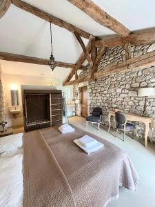 ein Schlafzimmer mit einem Bett und einer Steinwand in der Unterkunft Landhuis, oneindig uitzicht, 30ha land, privé zwembad in Auradou
