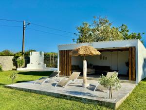 a group of chairs and an umbrella in a yard at Casa Maruxa in Valdoviño