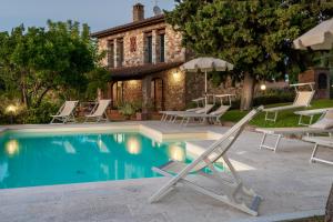 ein Swimmingpool mit Liegestühlen und ein Haus in der Unterkunft GLI SPILOCCHI 16, Emma Villas in Gambassi Terme