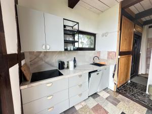 a kitchen with white cabinets and a sink at Domki Machnice in Machnice