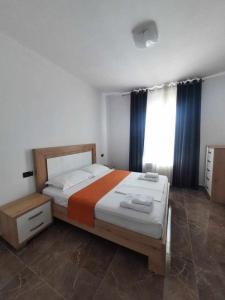 ein Schlafzimmer mit großem Bett und Fenster in der Unterkunft Era Palace Apartments in Vlorë