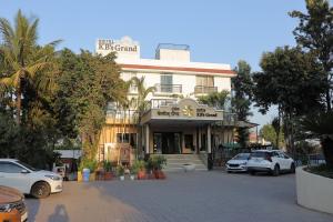 a building with cars parked in front of it at HOTEL KB's Grand in Shirdi