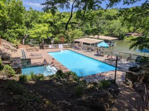 a large swimming pool with people sitting around it at Treetop Village-3Bed3BAPoolsLakefrontLakeview in Four Seasons