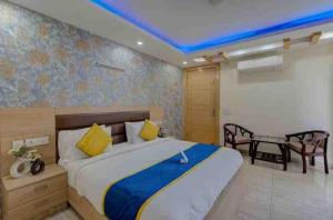 1 dormitorio con 1 cama grande y techo azul en Hotel Blue Neck Hudda City Centre Fortis Hospital, en Gurgaon 16 fotos más