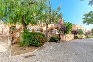 a building with a tree and flowers on a street at Entre o Vale e o Mar - Vale Parra in Guia