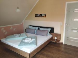 a bedroom with a bed with white sheets and purple pillows at Haus Fernblick in Breitungen