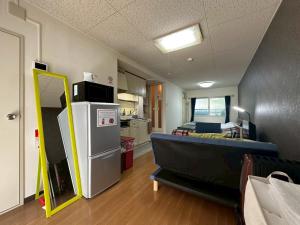 a room with a kitchen and a room with a refrigerator at カサデューク平岸45 in Toyohira