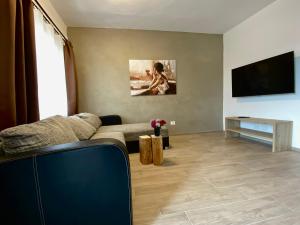a living room with a couch and a flat screen tv at Villetta Moscal - Buon Gusto in Affi