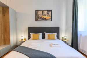 een slaapkamer met een groot wit bed met gele kussens bij Studio Modern 10 in Braşov