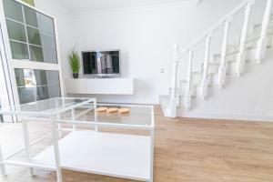 una stanza bianca con un tavolo di vetro e scale di Casa La Serena - Casa con patio en Zahara a Zahara de los Atunes