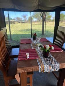 uma mesa numa tenda com flores em Zuhumath Tented Camps Serengeti em Parque Nacional Serengeti