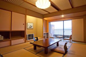 a living room with a table and a television at Suigekka in Wakasa