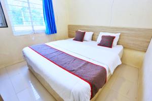 a bedroom with a large bed with two pillows at Nusantara Bunga By Reccoma in Tengahgirang +31 photos