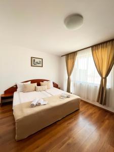 a bedroom with a large bed with two towels on it at Family Hotel Helios in Sunny Beach +53 photos