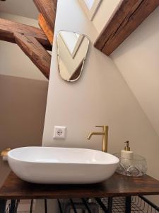 a bathroom with a white sink and a mirror at Slapen in de Paardenstraat in Zierikzee
