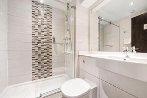 a white bathroom with a toilet and a sink at Sidcot Arms in Winscombe