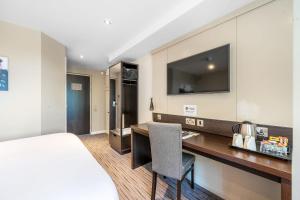 a hotel room with a bed and a desk and a tv at Sidcot Arms in Winscombe