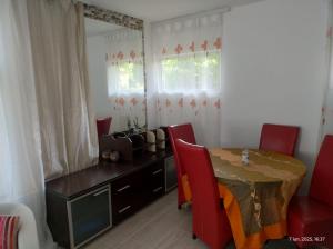 a dining room with a table and red chairs at Vila Ani in Techirghiol
