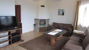 a living room with a couch and a table and a fireplace at Amampuri Village in Pamporovo