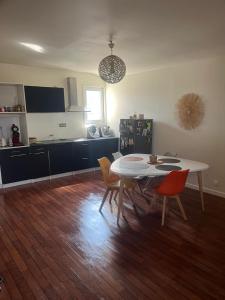 a kitchen with a table and chairs in a room at Appartement chaleureux au cœur de la ville in Saintes
