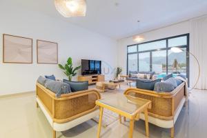 a living room with two couches and a table at Facing Arabian Gulf and Mountain 4BR Villa and Assistant Room with Outdoor Pool and BBQ Space, Al Dana Island, Fujairah by Deluxe Holiday Homes in Fujairah