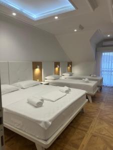 a room with four beds and a blue ceiling at Hotel RR in Herceg-Novi