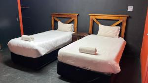 two beds sitting next to each other in a room at Miners Rest Lodge in Phalaborwa