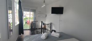 a bedroom with a bed and a television on the wall at La casita in Pontevedra