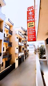 帕格瓦拉SYL HOTELS One - Comfortable and Secure Stays的一栋公寓楼的空走廊上挂着一个标志