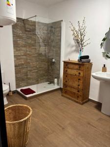 a bathroom with a shower and a wooden dresser at Cortijo Paulenca in Almería