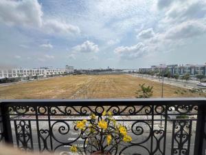 a vase of flowers on a balcony with a field at Hotel AN KHƯƠNG in Rach Gia