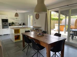 a kitchen and dining room with a wooden table and chairs at Barsy La belle des champs in Havelange