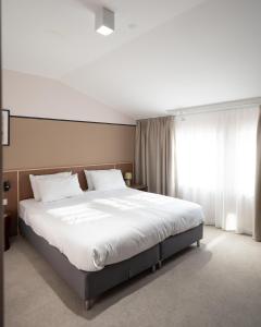 Postel nebo postele na pokoji v ubytování Hotel Admiral Vinkovci