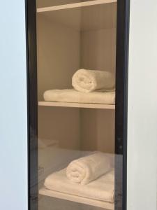 TürkistanにあるЖк Караван Сарайの白いタオルが入ったガラスのキャビネット