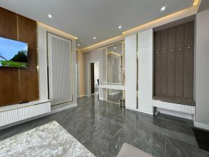 TürkistanにあるЖк Караван Сарайのテレビといくつかのキャビネットがある広い部屋