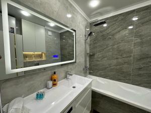 TürkistanにあるЖк Караван Сарайの洗面台、浴槽、鏡のあるバスルーム +21枚の写真