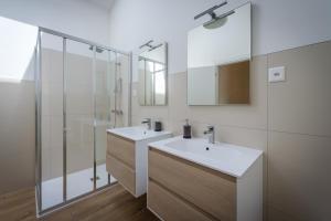 uma casa de banho com 2 lavatórios e um chuveiro em Viganello Modern Apartments em Lugano mais 37 fotografias