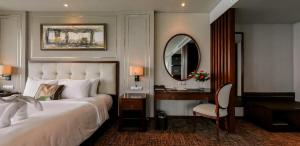 a bedroom with a bed and a desk and a mirror at Boton Blue Hotel & Spa in Nha Trang